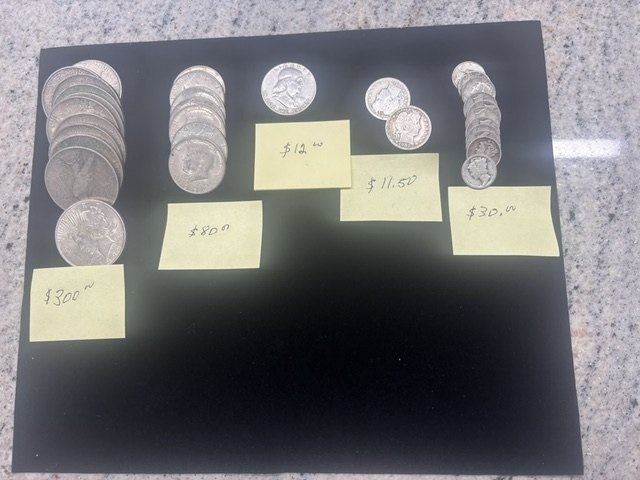 Silver dollars, halves and dimes sorted and priced for a customer