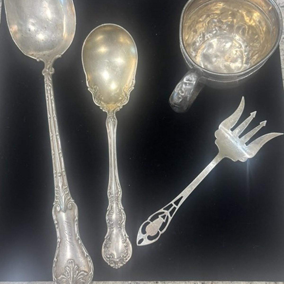 Sterling silver serving spoons, a christening cup and a pierced serving fork purchased from a local customer